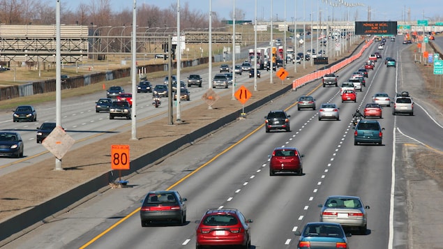 Des cônes orange bordent le long d'une autoroute. 