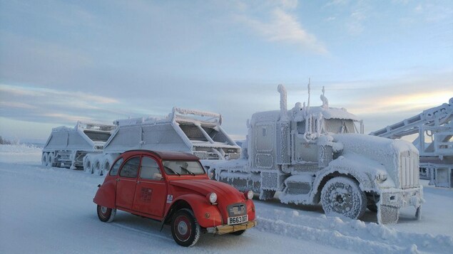 La 2 CV garée près d'un gros camion couvert de neige et de glace. La 2 CV garée près d'un gros camion couvert de neige et de glace.