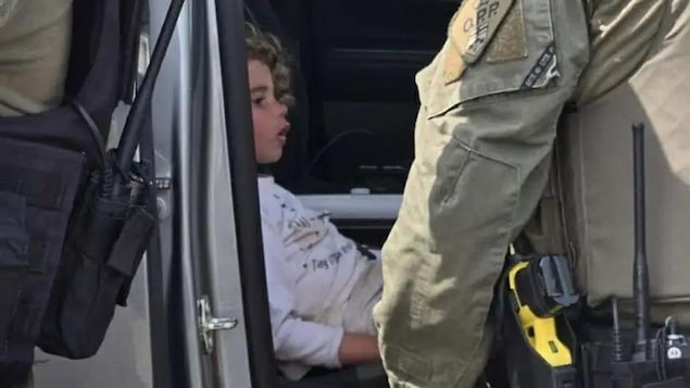 Claire Bell assise dans une voiture de police.