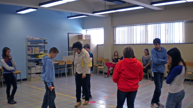 Des élèves marchent sur un plan cartésien recréé au sol d'une classe. Des élèves marchent sur un plan cartésien recréé au sol d'une classe.