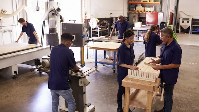 Des jeunes en formation dans un atelier d'ébénisterie
