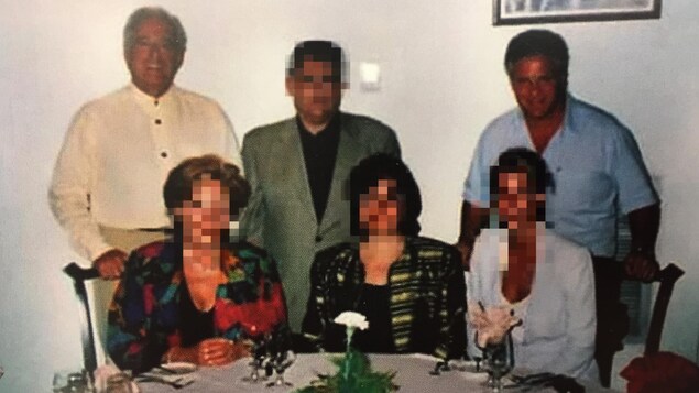 Claude Asselin et Tony Accurso entourent un autre homme, debout derrière une table où sont assises trois femmes, dont le visage a été brouillé. Claude Asselin et Tony Accurso entourent un autre homme, debout derrière une table où sont assises trois femmes, dont le visage a été brouillé.