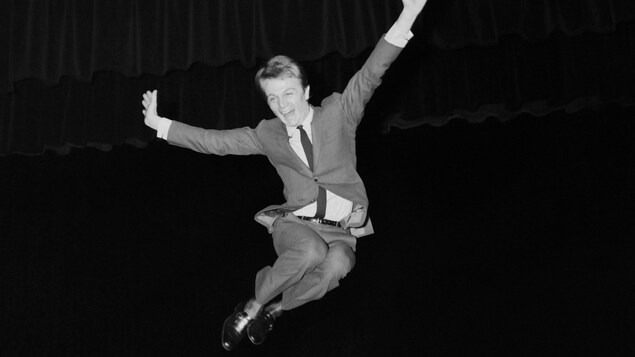 Le chanteur saute dans les airs sur scène. Le chanteur saute dans les airs sur scène.