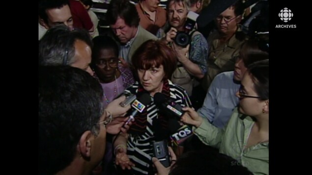 Claudette Carbonneau au milieu d'un attroupement de journalistes. 