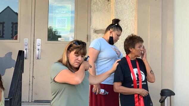 Trois femmes émues essuient des larmes.