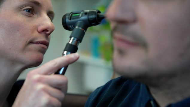 Une médecin examine un patient.
