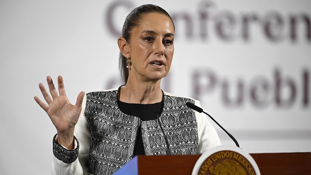 Claudia Sheinbaum parle en montrant une main ouverte, doigts écartés, lors d'une conférence de presse.