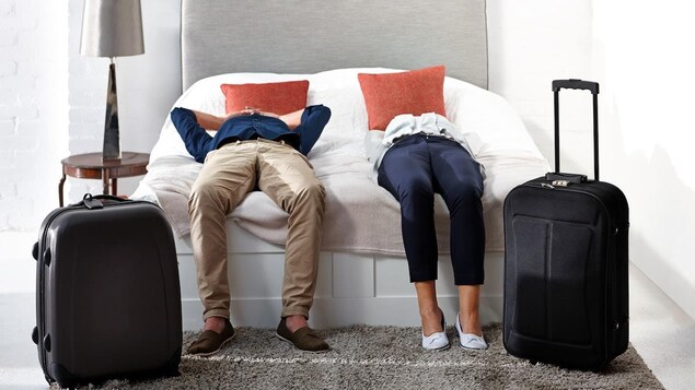 Les clients d'un hôtel étendus sur le lit de leur chambre.