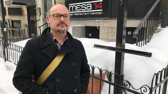 Mike Cloghezy à l'extérieur et portant un manteau noir devant son restaurant fermé et enneigé Mike Cloghezy à l'extérieur et portant un manteau noir devant son restaurant fermé et enneigé