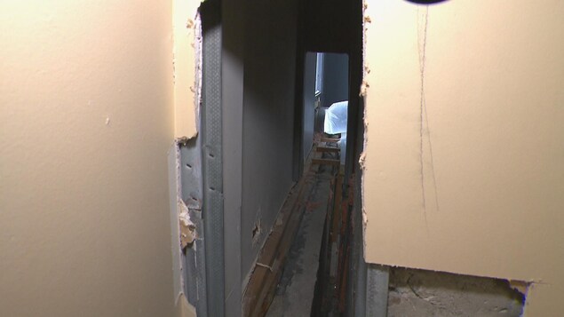 Un mur a été ouvert. On peut y voir du bois et de la poussière. Un mur a été ouvert. On peut y voir du bois et de la poussière.