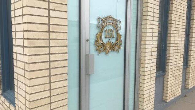 La porte d'entrée du club privé d'effeuillage Regina 151 est vitrée, mais les rideaux sont tirés. L'immeuble est en briques beiges. La porte d'entrée du club privé d'effeuillage Regina 151 est vitrée, mais les rideaux sont tirés. L'immeuble est en briques beiges.
