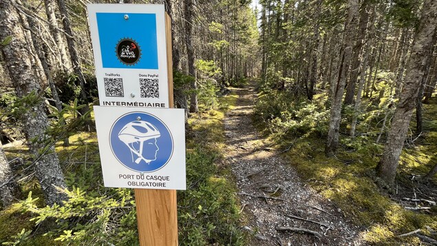 Une affiche rappelle aux utilisateurs du sentier de vélo de toujours porter un casque.