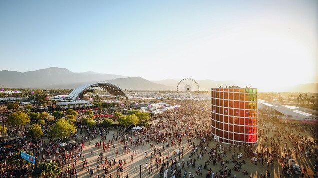 Une foule marche vers différents sites du festival. Au loin se dresse une grande roue