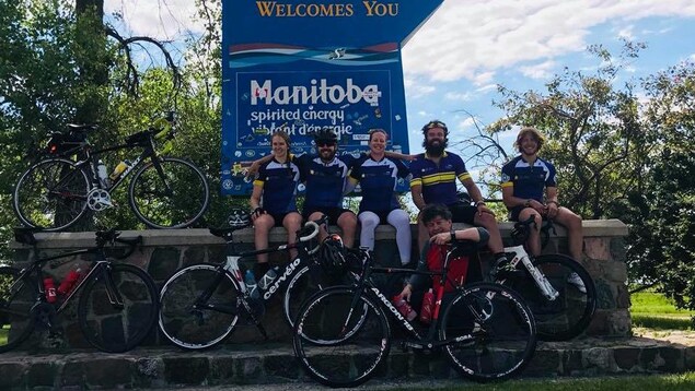La famille Collin pose devant une affiche qui souhaite la bienvenue aux visiteurs qui entrent au Manitoba. La famille Collin pose devant une affiche qui souhaite la bienvenue aux visiteurs qui entrent au Manitoba.