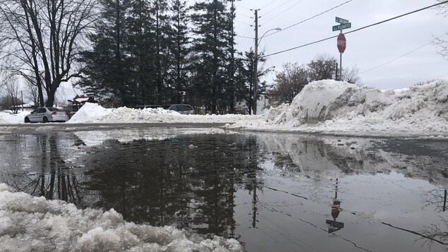 Une grande flaque d'eau sur la chaussée en hiver.