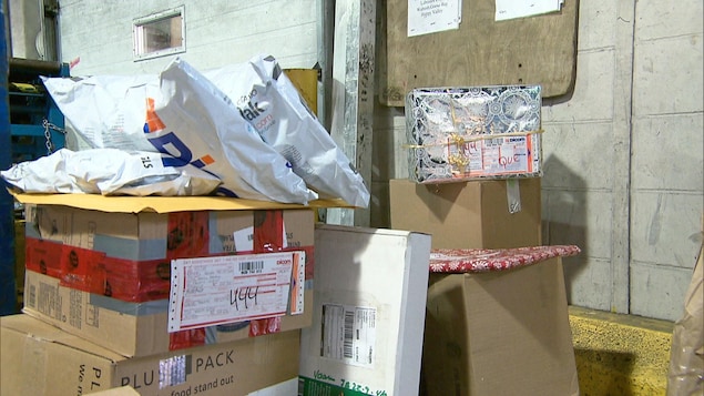 Des boîtes de carton avec du ruban adhésif une par dessus l'autres dans un entrepôt.