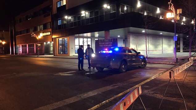 Une voiture de police dan une rue fermée.