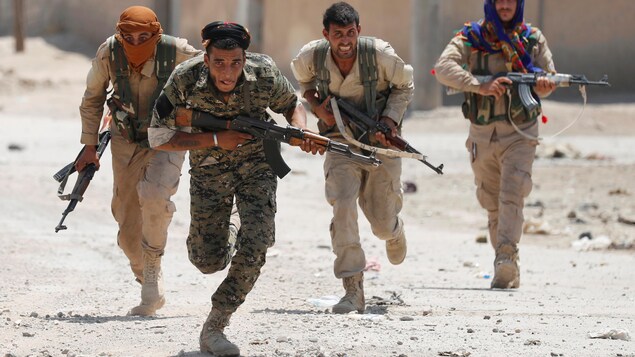 Des combattants kurdes montent à l'assaut dans la ville de Raqqa, en Syrie. Des combattants kurdes montent à l'assaut dans la ville de Raqqa, en Syrie.