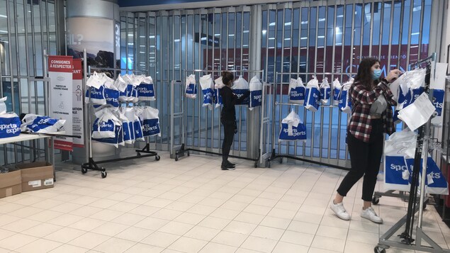 Des employés du magasin Sports Experts, à Québec, préparent des commandes à l'auto.