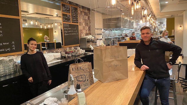 Une femme et un homme, séparé par un comptoir, dans un restaurant.