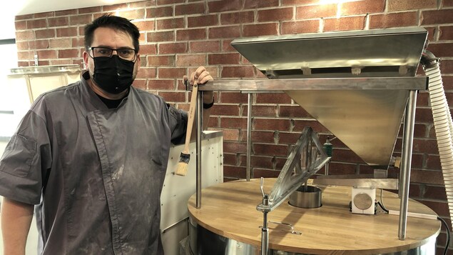 Un boulanger devant un moulin à grains