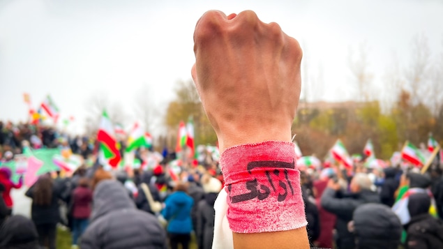 Le mot « liberté » inscrit en farsi sur un bracelet attaché autour d'un poing levé durant une manifestation contre le régime iranien à Toronto, le 12 novembre 2022.