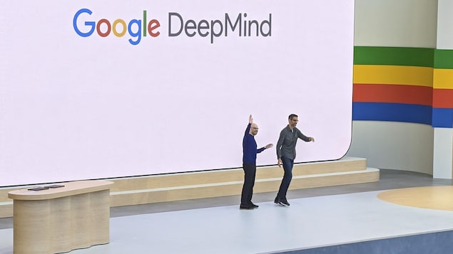 Deux hommes sont accueillis sur scène, lors d'une présentation de Google en plein air. 