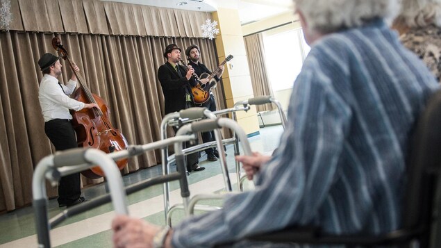 Músicos tocan frente a ancianos.