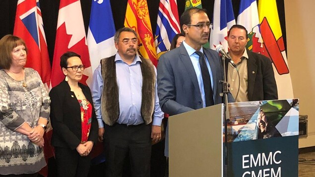 Les ministres provinciaux et territoriaux écoutent le ministres canadiens parler au micro. Les ministres provinciaux et territoriaux écoutent le ministres canadiens parler au micro.
