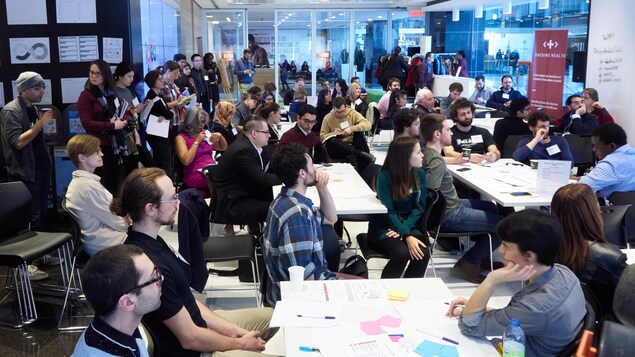 Des dizaines de personnes dans une grande salle