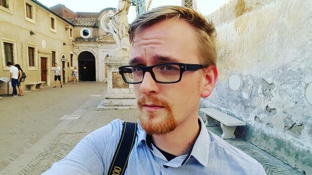Brian Topp esquisse un sourire dans la cour extérieure d'un musée.