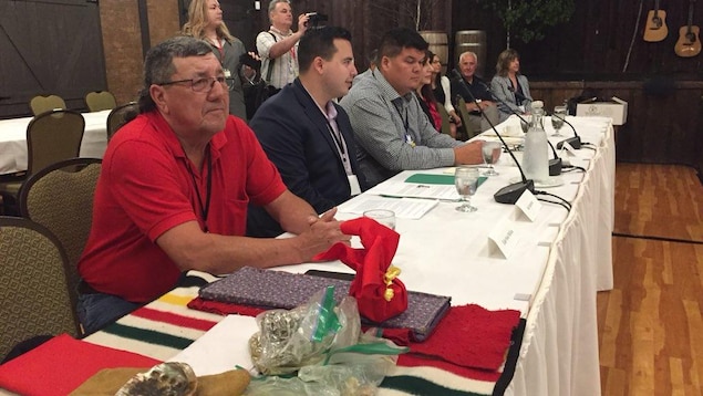 Une dizaine de délégués assis à une table devant les premiers ministres Une dizaine de délégués assis à une table devant les premiers ministres