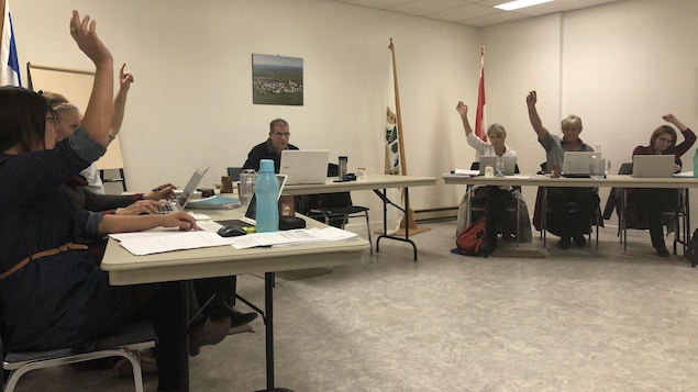 Le maire de Saint-Paul-de-la-Croix, Simon Périard et des conseillers municipaux votent sur une résolution.