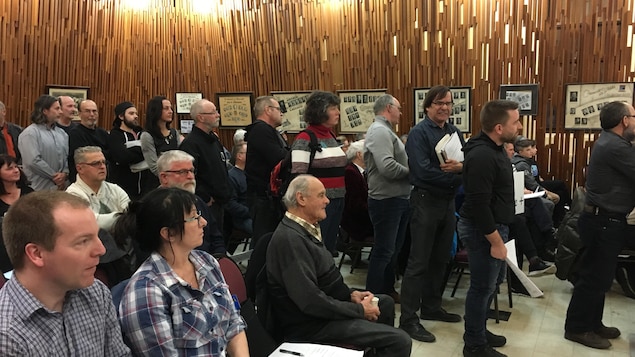 Des citoyens attendent en file pour poser une question lors d'une séance du conseil de Ville de Saguenay.