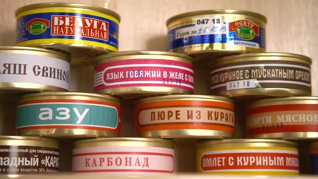 On voit en gros plan des conserves qui portent des inscriptions en russe.