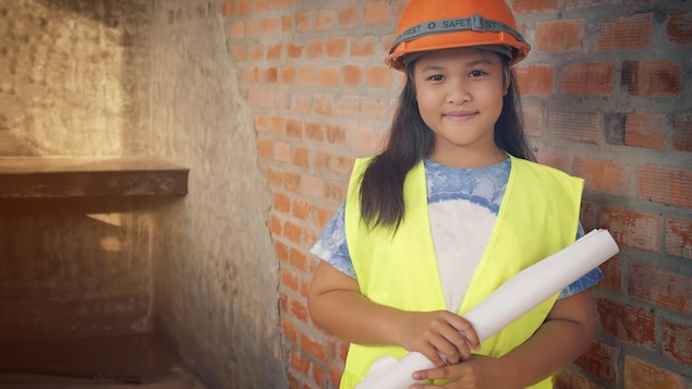Jeune fille vêtue d'un casque de construction. Jeune fille vêtue d'un casque de construction.