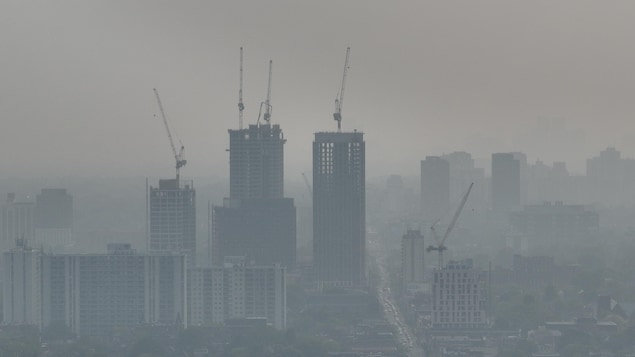 Images aériennes de l'horizon de la ville de Toronto (ouest) recouvert d'une épaisse couche de smog, due à la fumée des incendies de forêt dans les prairies. Une alerte à la qualité de l'air est en vigueur.