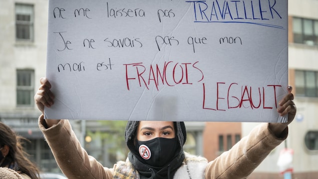 Una mujer sostiene un cartel de rechazo a la Ley 21.