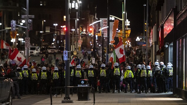 Police officers stood guard as they worked to restore normality to Ottawa on Feb. 19, 2022, while trucks and demonstrators continued to occupy the downtown core to protest against pandemic restrictions.