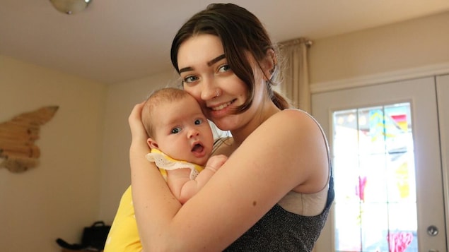 Corale Mayer holds her baby in her arms.