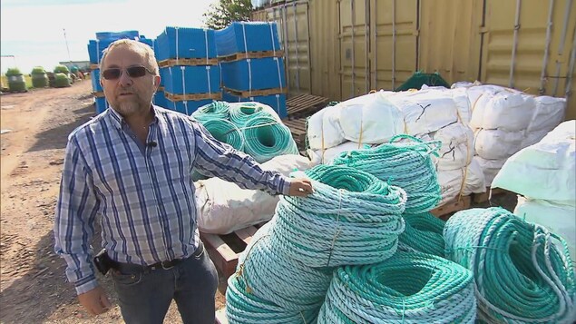Le pêcheur Daniel Desbois sur le bord de l'eau pose à côté de plusieurs rouleaux de cordage. Le pêcheur Daniel Desbois sur le bord de l'eau pose à côté de plusieurs rouleaux de cordage.