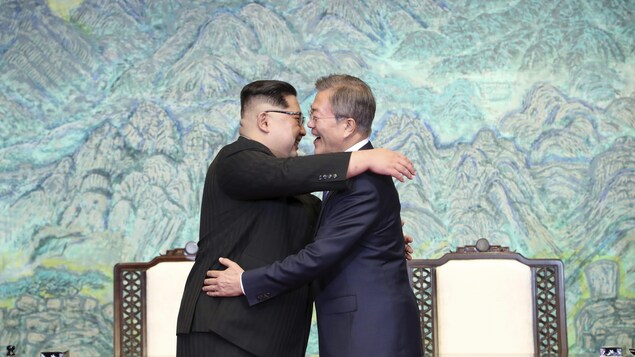 Deux hommes se font l'accolade.