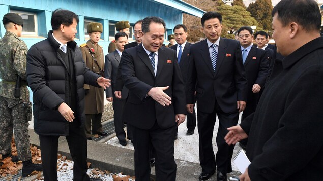 Le chef de la délégation nord-coréenne Ri Son-gwon s'apprête à serrer la main d'un diplomate sud-coréen après avoir franchi la frontière militarisée entre les deux pays. Le chef de la délégation nord-coréenne Ri Son-gwon s'apprête à serrer la main d'un diplomate sud-coréen après avoir franchi la frontière militarisée entre les deux pays.