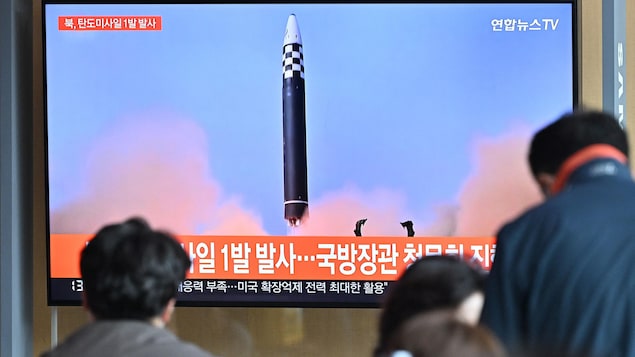 Dans une gare à Séoul, des personnes regardent un écran de télévision sur lequel sont diffusées des images d'un tir de missile nord-coréen.
