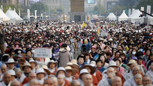 Des milliers de bouddhistes participent à une prière en plein air. À l'avant-plan, des moines bouddhistes. Des milliers de bouddhistes participent à une prière en plein air. À l'avant-plan, des moines bouddhistes.