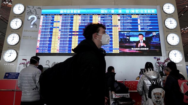 Un voyageur portant un masque circule dans un aéroport des Philippines.