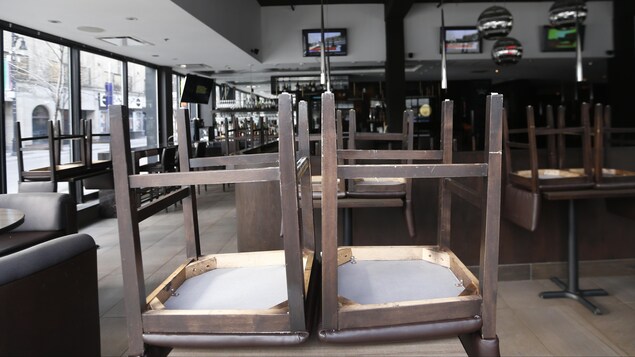 Des chaises sur des tables dans un restaurant fermé.