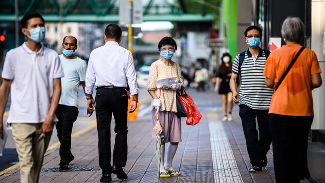 Des piétons portent des masques dans le quartier Sham Shui Po de Hong Kong.