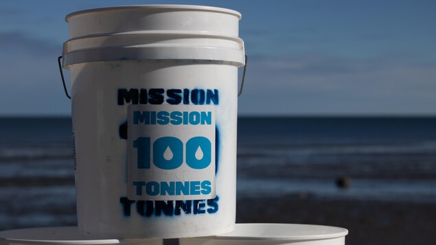 Seau sur lequel on peut lire ''Mission 100 tonnes''.