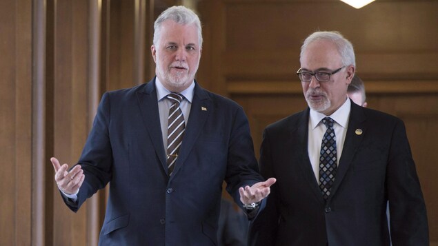 Le premier ministre du Québec, Philippe Couillard, accompagné de son ministre des Finances, Carlos Leitao, mardi le 14 mars 2017, avant une réunion du caucus du Parti libéral du Québec, à Québec.